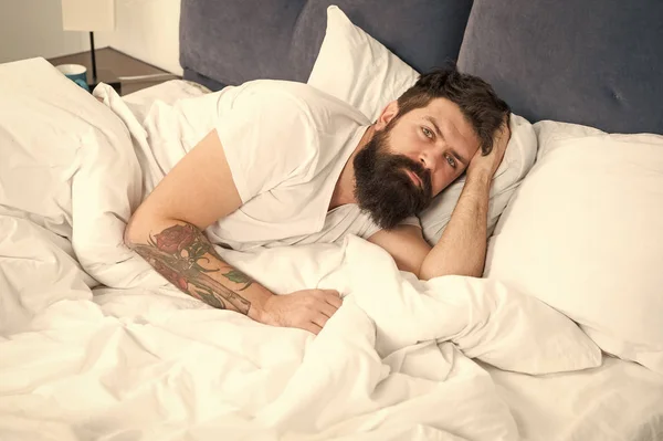 Homem barbudo hipster tendo problemas com o sono. O tipo deitado na cama tenta relaxar e adormecer. Técnicas de relaxamento. Violações do sono e da vigília. Preciso de descansar. Conceito de distúrbios do sono — Fotografia de Stock