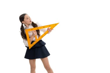 Eğitim. Okul dersinde ölçme aleti olan küçük çocuk. Küçük kız geometri dersine hazırlanıyor. Sevimli kız öğrenci ders için üçgen cetveller tutun