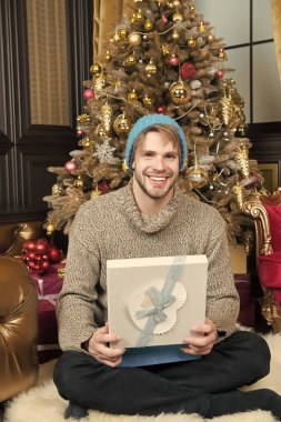 Hediye kutusu oturup Noel ağaç adam gülümseyerek