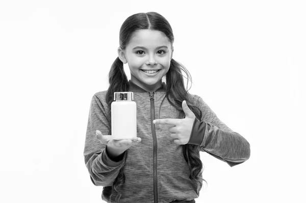 Apresentando o produto. Criança a apontar para o frasco da pílula. Menina pequena com pílula de medicina e complexo vitamínico. Criança adorável com pílula vitamínica. Saúde. Ajuda à saúde. Vitamina em comprimidos. Comprimido para a saúde — Fotografia de Stock