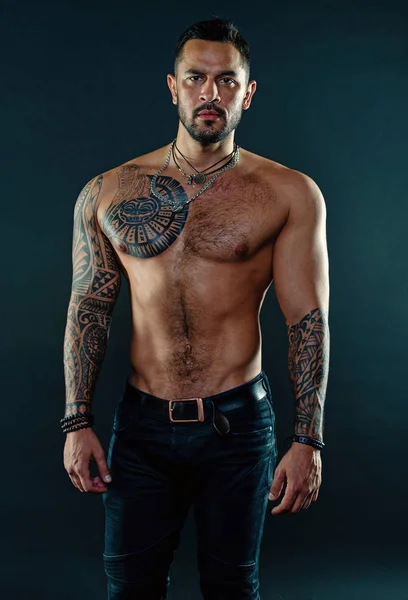 Man handsome shirtless muscular with jeans over dark background. Muscular tattooed athlete look attractive. Sport and fashion concept. Handsome fit man posing wearing in jeans with tattoo. Tattoo art — Stock Photo, Image