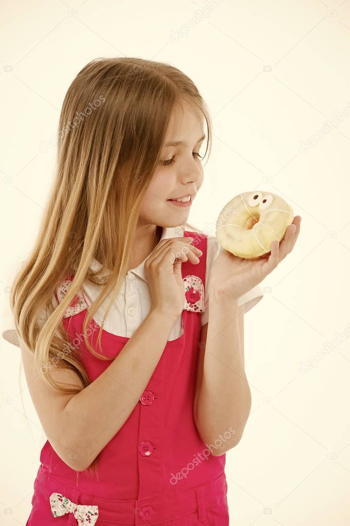 How bad are sweets for your kids. Girl cute smiling face holds sweet donut. Girl likes sweets as donuts. Avoid rewards with sugar. Kid rewarded for good behavior with sugary treats