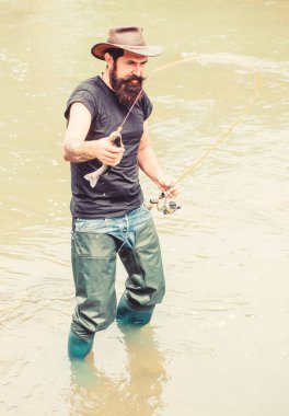 Bay Balıkçılık Adventures. yaz hafta sonu. Balık avlamak için uç. Suda mutlu sakallı balıkçı. balıkçı göstermek balıkçılık tekniği çubuk kullanın. hobi ve spor aktivitesi. olgun adam balıkçılık sinek. adam balık yakalamak