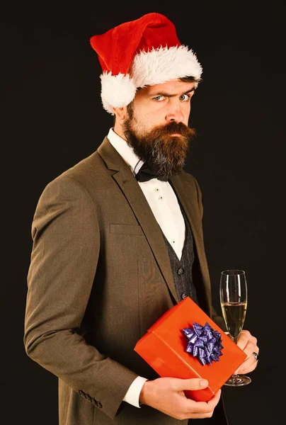 Man in classic suit and Santa hat on brown background.