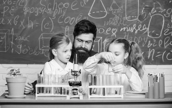 Professora de Biologia. Homem barbudo professor trabalhar com microscópio e tubos de ensaio em sala de aula de biologia. Como interessar crianças estudam. Explicar biologia às crianças. Lição de biologia fascinante — Fotografia de Stock