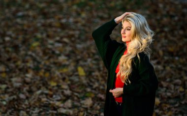 Uzun saç bakım konsepti. Sonbaharda saçınıza nasıl dikkat edin. Nasıl hızlı ve güvenli bir şekilde saç ağartılmış tamir. Sonbahar saç bakımı böylece kuru kıvırcık saç modeli önlemek için önemlidir. Kız sarışın sonbahar parkı yürüyüş