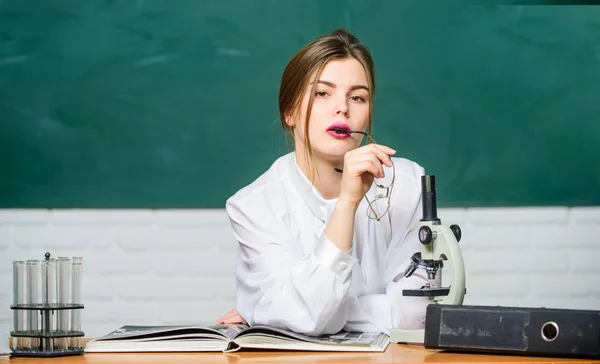 Student biologii siedzieć w klasie tło tablica. Biolog chemik z mikroskopem. Inteligentny uczeń. Studiuj ciężko. Badania naukowe. Koncepcja edukacyjna. Kobieta całkiem urocza Nauczycielka lub studentka — Zdjęcie stockowe