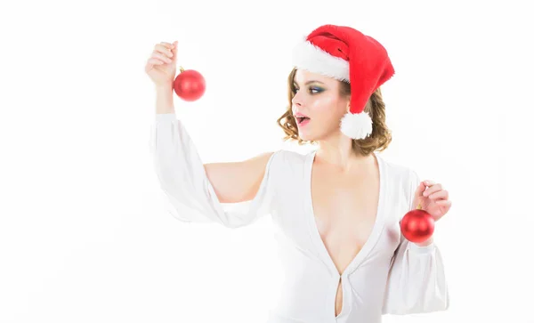 크리스마스를 준비합니다. 크리스마스 파티를위한 메이크업과 헤어 스타일 준비 소녀. 여자는 섹시한 드레스를 입고 산타 모자는 흰색 배경에 장식 공을 보유하고 있습니다. 크리스마스 파티를위한 메이크업과 의상 — 스톡 사진