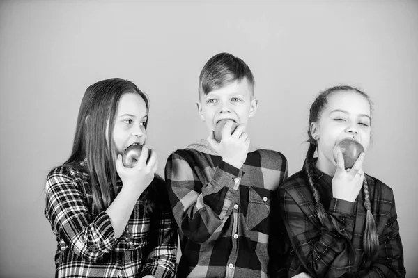 An apple a day keeps the doctor away. Little children biting red apples. Small group of children eating apples together. Cute children enjoying tasty juicy apples — Stock Photo, Image