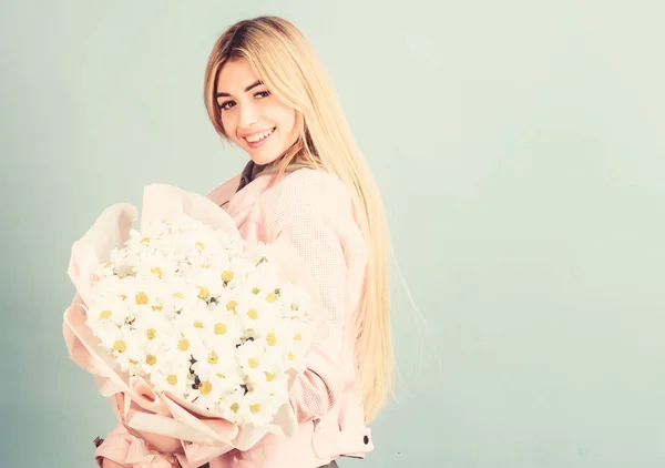 Celebrating her special day. Surprise for girlfriend. Adore flowers. Girl tender sensual blonde hold flowers bouquet. Flowers delivery service. Chamomile flower symbol of innocence and tenderness