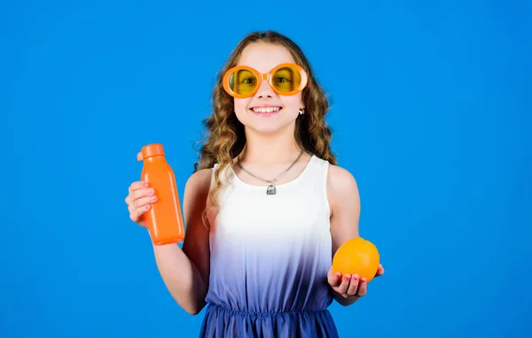 Chica feliz beber jugo de naranja fresco. vacaciones de verano. Niña con gafas de moda. Nutrición con vitaminas. jugo de vitaminas. Salud. Dieta de verano con vitaminas. Fuente natural de vitaminas. Tomar decisiones nutricionales — Foto de Stock