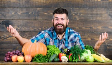 Sebze organik hasat. Çiftçi rustik tarzı adam. Doğal gıdalar. Vejetaryen yaşam tarzı kavramı. Adam sakallı çiftçi hasat ahşap arka plan. Çiftliğime hoş geldin. Yerli sebzeli çiftçi