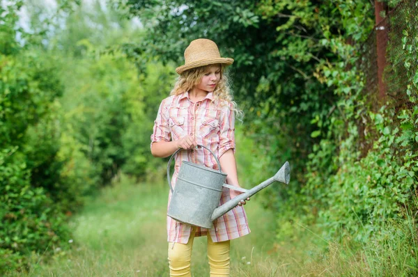 Girl child hold watering can. Spring gardening checklist. Watering tools. Measure soil water content temperature and salinity. Improve irrigation timing. Optimize water use. Watering plants in garden — Stock Photo, Image