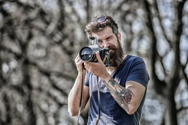 Criador de conteúdo. Fotógrafo hipster barbudo. Fotógrafo com barba e bigode. Homem de barba comprida a fotografar. Configurações manuais. Fotógrafo segurar câmera vintage. Blogueiro moderno — Fotografia de Stock