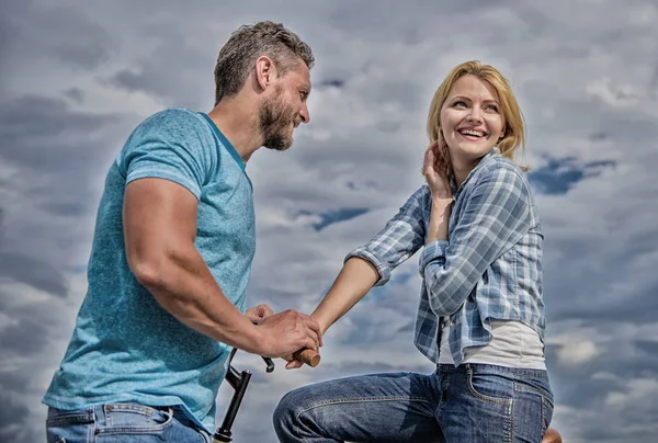 asual acquaintance concept. Man with beard and shy blonde girl on first date. Couple just meet to hang out together. Woman feels shy in company with attractive macho. Rolling romance or bike date