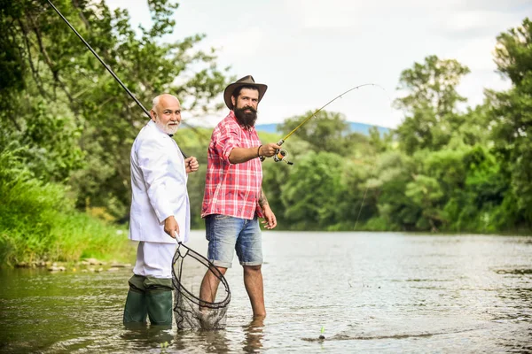 Día de la familia. Equipo de pesca. Amigos pescando. Un fin de semana perfecto. Atrapar con éxito. Relájese en el entorno natural. Elegante hombre barbudo y brutal pesca hipster. Hobby y recreación. Vacaciones de verano —  Fotos de Stock