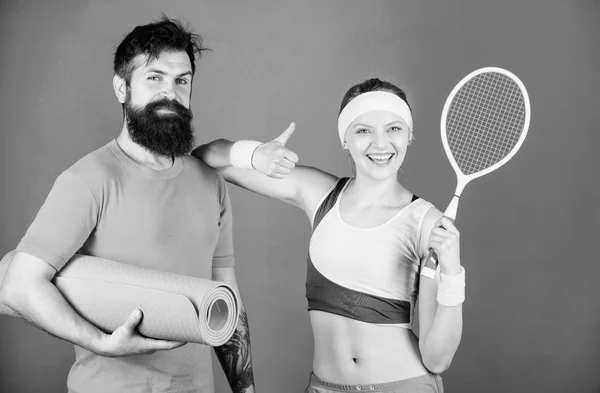 Get your Game on. Strong muscles and body. Sporty couple training with fitness mat and tennis racket. Athletic Success. Sport equipment. Happy woman and bearded man workout in gym — Stock Photo, Image