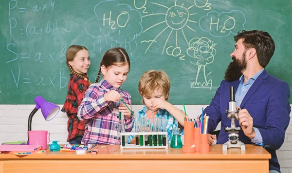 Wissenschaft ist immer die Lösung. Reaktion beobachten. Experiment Schulchemie. Faszinierender Chemieunterricht. Mann bärtige Lehrer und Schüler mit Reagenzgläsern im Klassenzimmer. Kindern Chemie erklären — Stockfoto