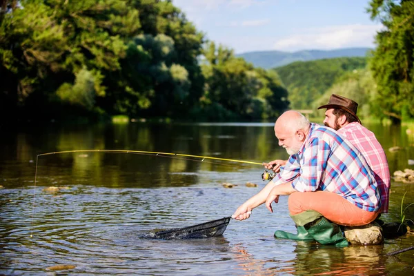 Poachers fishing. Black market caviar. Illegal hunting caviar. Extracts eggs from sturgeon caught river. Trap for fish. Men sit at riverside with fishing equipment. Poaching crime and fishing license — Stock Photo, Image