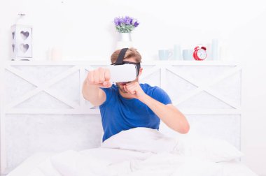 Bu yeni teknolojiden faydalanıyor. Beyaz adam evde eğlenmek için sanal gerçeklik teknolojisi kullanıyor. Yenilikçi teknoloji deneyimi olan yakışıklı bir adam. Teknoloji burada.