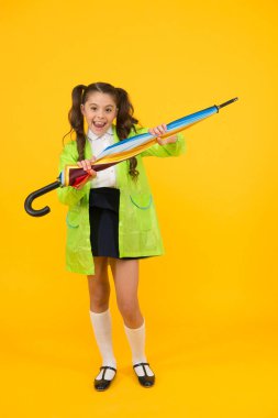 Suya dayanıklı giysiler. Yağmur geçirmez kıyafetler. Yağmur bitti. Yağmur yağıyor. Yağmurlu günleri bekliyorum. Şemsiye ile Schoolgirl şık küçük çocuk su geçirmez yağmurluk giymek. Sonbahar yağmuru. Okula gitmek
