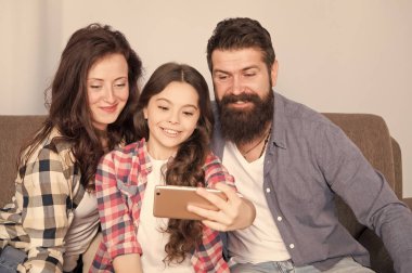 Aile selfie. Aile birlikte hafta sonu geçirmek. Smartphone için selfie kullanın. Dostu aile birlikte eğleniyor. Anne baba ve kızı kanepede rahatlatıcı. Aile fotoğrafı için poz. Mutlu anları yakalamak
