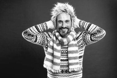 İnsan için kışlık gardırop. Olgun model soğuk hava tarzı sahiptir. Sakallı adam şapka ve eşarp ile kazak accessorizing. Kış seti onu soğuktan korur. Soğuk sezon için, siyah ve beyaz