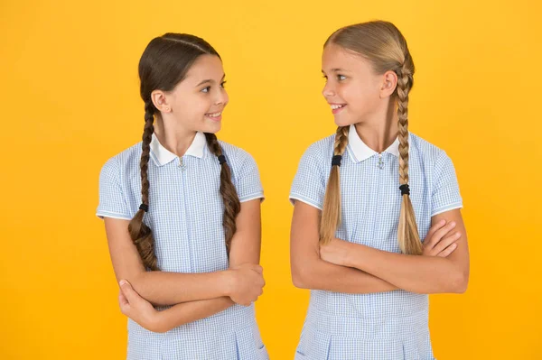 Szczęśliwego dzieciństwa. brunetka i blond włosy. koncepcji siostry. Najlepsi przyjaciele. stylu Vintage. małe dziewczynki w retro Uniform. starej szkoły mody. Powrót do szkoły. szczęśliwe piękno z warkoczami. osobisty styl — Zdjęcie stockowe