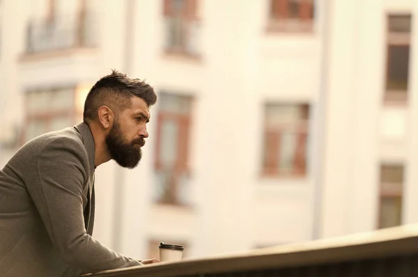 A tasty way to start his day. Businessman in hipster style holding takeaway coffee. The best time of day to drink coffee. Hipster with paper cup walking in city. Bearded man enjoying morning coffee — Stock Photo, Image