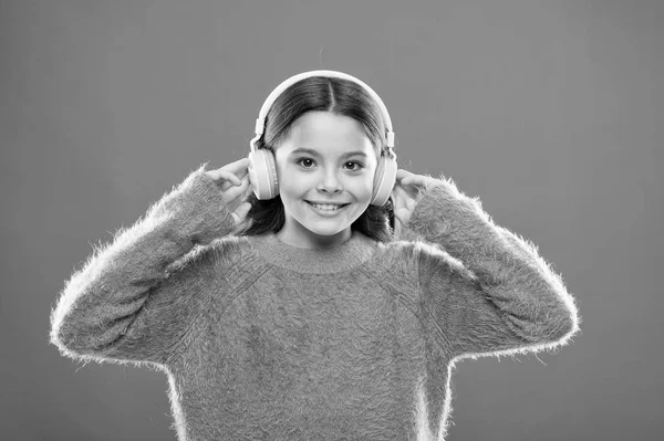 Dźwięk dociera do jej uszu ze słuchawkami. Małe dziecko słuchające muzyki w słuchawkach bezprzewodowych. Dziewczynka w nowoczesnych słuchawkach. Cute kid korzystających z dźwięku stereo w słuchawkach — Zdjęcie stockowe