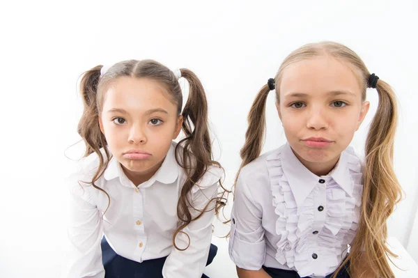 Cuties infelizes. Pequenos alunos infelizes isolados em branco. Meninas pequenas adoráveis com emoções infelizes olhando na câmera. Infeliz por causa da escola começa — Fotografia de Stock