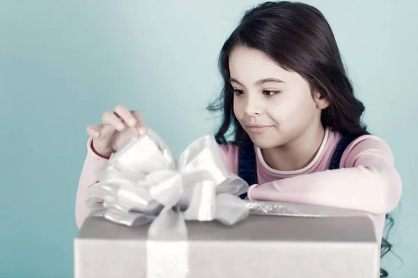 Лента прикосновения ребенка бант на подарочной коробке на голубом фоне — стоковое фото