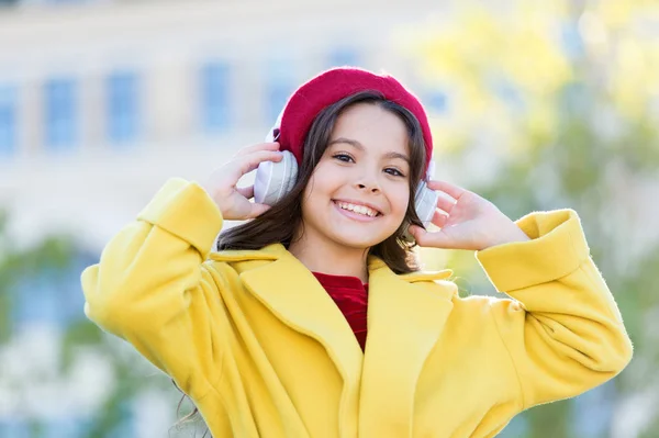 Mädchen mit Kopfhörer städtischen Hintergrund. Überspringen Sie die Strecke. Lieblingsband. Einfluss der Musik. Kind Mädchen Herbst Outfit genießen Musik. Musikgeschmack von Teenagern. Kleines Mädchen hört Musik und genießt Lieblingslied — Stockfoto