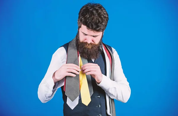 Discover trendy mens fashion in our shop. Bearded man choosing luxury necktie in menswear shop. Shop assistant offering wide choice of finest neckties. Shop for mens clothes and accessories