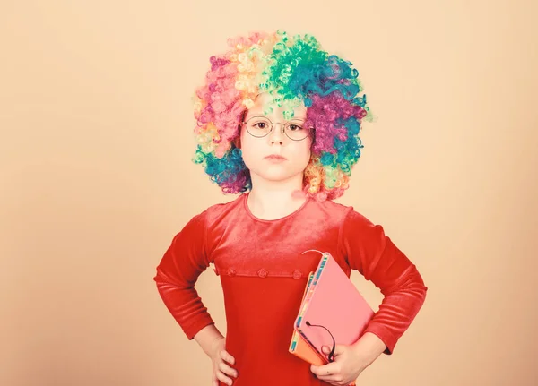 Make studying fun. Truly happy childhood. Girl cute playful child wear curly rainbow wig. Life is fun. Happy little child girl. International childrens day. Happy moments. Adorable baby having fun