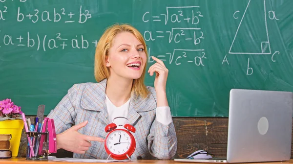 Justo a tiempo. profesor con despertador en pizarra. El tiempo. mujer en el aula. De vuelta a la escuela. Día del maestro. Estudio y educación. Escuela moderna. Día del conocimiento. En la escuela. Enseñanza en casa. mujer feliz — Foto de Stock