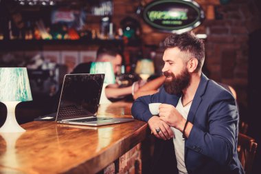 İçerik web günlüğü oluşturun. Yönetici sonrası kahve keyfini oluşturun. Hipster serbest çalışan online kahve içme çalışır. Kahve molası konsepti. Adam sakallı işadamı dizüstü bilgisayar ve kahve fincan ı ile bar sayacı oturup
