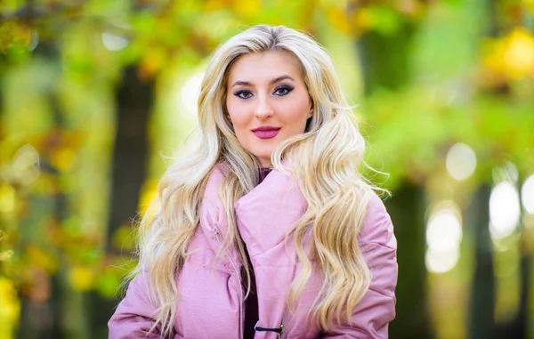 Autumn hair care is important so as to avoid dry frizzy hair. How to repair bleached hair fast and safely. Girl fashionable blonde walk in autumn park. Autumn hair care concept. Cold blonde concept