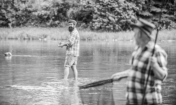 Reel friendship. two fishermen with fishing rods, selective focus. mature man fisher. hobby and sport activity. son and father fishing. male friendship. family bonding. summer weekend — Stock Photo, Image