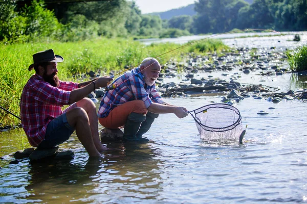 Furto di frodo e licenza di pesca. Caviale del mercato nero. Caviale illegale da caccia. Estrae uova da storione catturato fiume. Trappola per pesci. Gli uomini siedono sul lungofiume con l'attrezzatura da pesca. Pesca di bracconieri — Foto Stock