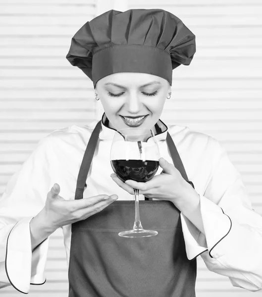 somellier with wine glass. woman in cook hat and apron. professional chef in kitchen. Cuisine. Housewife drink red wine. happy woman. Cheers to friends. Sommelier examining wine. This is perfect wine