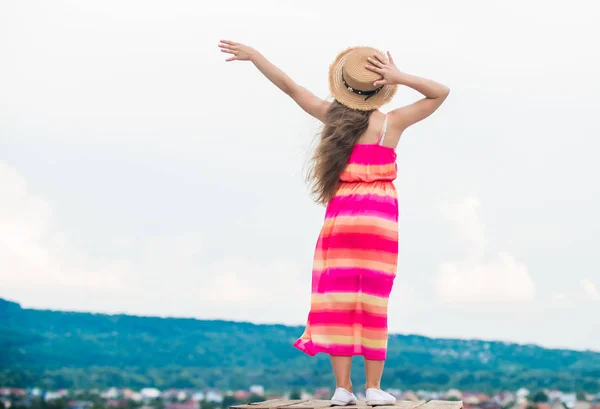 Succès futur. petite fille passer du temps en plein air. temps nuageux. heureux jour des enfants. enfant insouciant en robe d'été. petite fille aux longs cheveux bouclés. bonheur d'enfance. été enfant mode — Photo