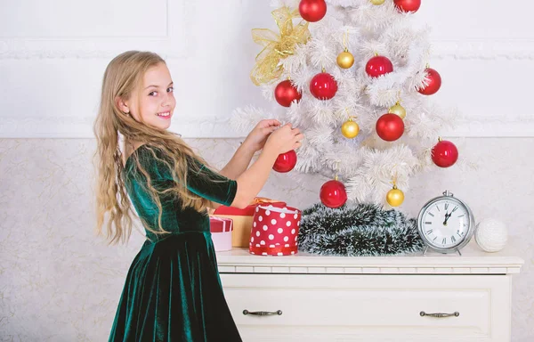 Κορυφαίες Χριστουγεννιάτικες ιδέες διακόσμησης για παιδικό δωμάτιο. Τα παιδιά μπορούν να λαμπρύνουν επάνω χριστουγεννιάτικο δέντρο, δημιουργώντας τη δική τους στολίδια. Κορίτσι γιορτάσουν τα Χριστούγεννα. Παιδί βάλει χριστουγεννιάτικο στολίδι μπάλα σε τεχνητό δέντρο λευκό — Φωτογραφία Αρχείου
