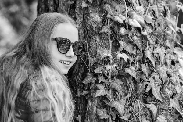 Bahar tatili. Yeşil çevre. parkta mutlu çocuk. Yaz. Doğal güzellik. Çocukluk mutluluğu. küçük kız parkta boş zaman geçirmek. sarmaşık yaprakları ile ağaç üzerinde tırmanma bitki. Çok güzelsin