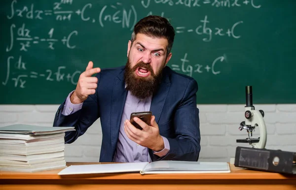 User experience. School teacher hold mobile phone chalkboard background. Teacher bearded man learn use modern technology. Learn technology. Modern communication. School application. Study technology