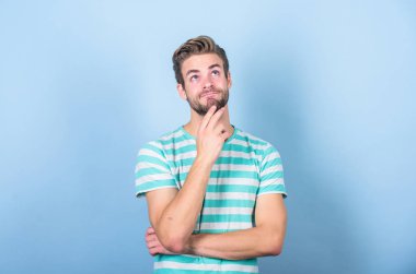 Zor bir soru. Adam ciddi yüz düşünceli. Bazı şüpheler içinde sınat. Düşünceli ifade. Düşünmem gerek. Çözüm bulun. Hipster sakallı yüzü bir şeyde emin değil. Mavi arka planda düşünceli adam