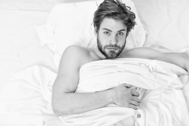 Genç adam yatakta uzanan gösteren resim. Adam gözlerini gevşeme ile kapatılır. Sabah yatak etkin komik.