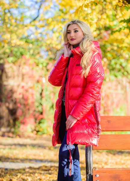 Vrouw modieuze blonde met make-up stand in de herfst Park. Jas voor herfst seizoen concept. Dame aantrekkelijk poseren in jas in de buurt van bench. Meisje dragen rode heldere warme jas. Fall Fashion concept — Stockfoto