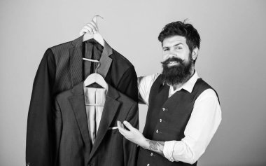 Yepyeni bir gardırop. Gardırop danışmanı resmi tarzı kat tavsiye. Hipster gardırop mağazasında takım elbise ceketi seçiyor. Erkek gardırobunda giysi koleksiyonu olan sakallı adam