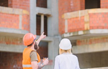 İnşaat ekibi iletişim kavramı. Planı tartışıyor. Kadın mühendis ve Oluşturucu inşaat alanında iletişim. İnşaat istemcileri ve inşaat sektöründe katılımcılar arasındaki ilişkileri